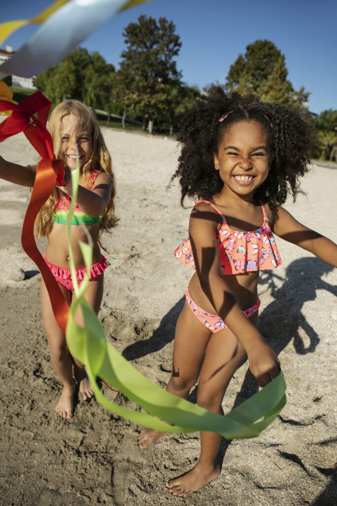 girls playing beach full shot