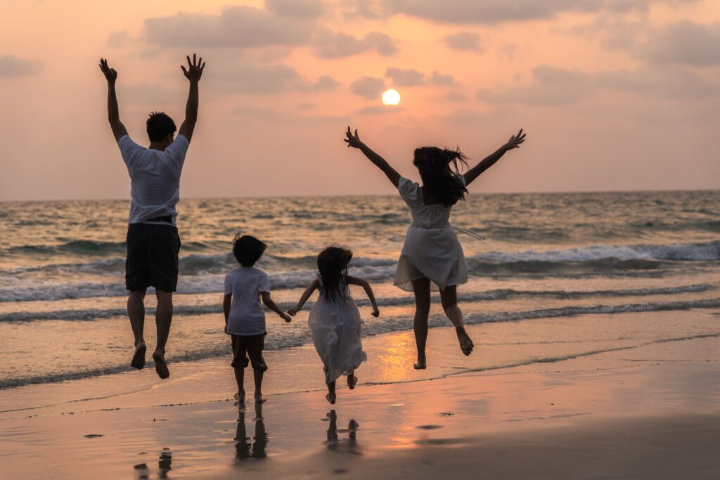 asian young happy family enjoy vacation beach evening dad mom kid relax running together near sea while silhouette sunset lifestyle travel holiday vacation summer concept (1)